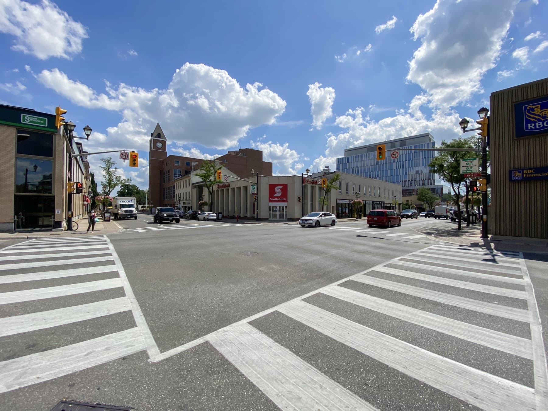 The intersection of Queen Street and Main Street in downtown Brampton, with the clock tower of City Hall and a glass office building behind it