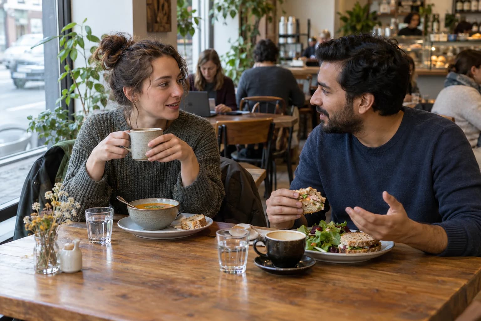 Two friends sharing sandwiches, soup and coffee at a neighbourhood cafe