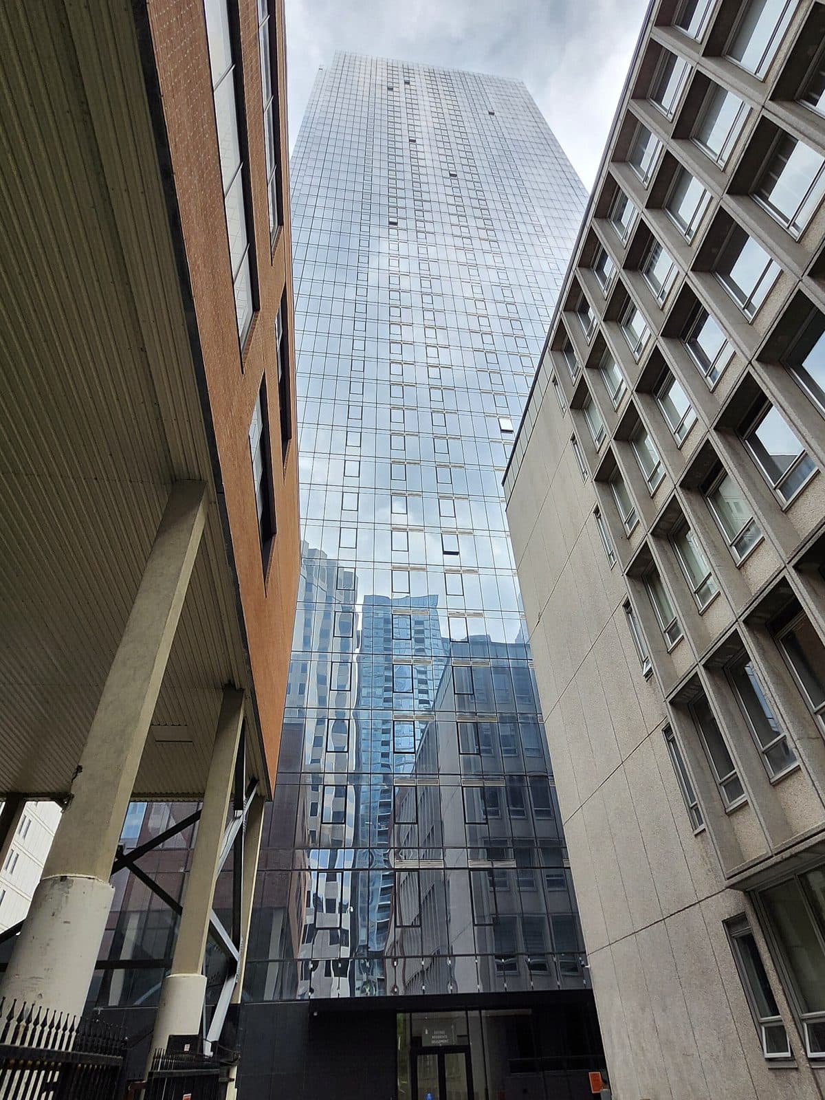 Looking up the glass face of 1 Square Phillips between older buildings