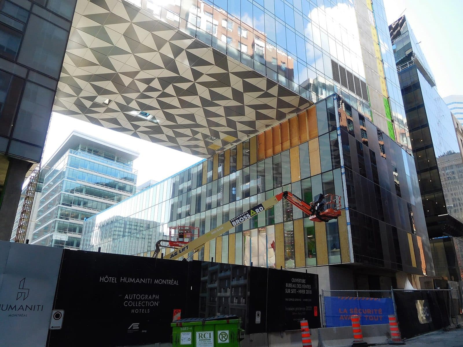 Humaniti's patterned overhang and glass facade above construction hoarding