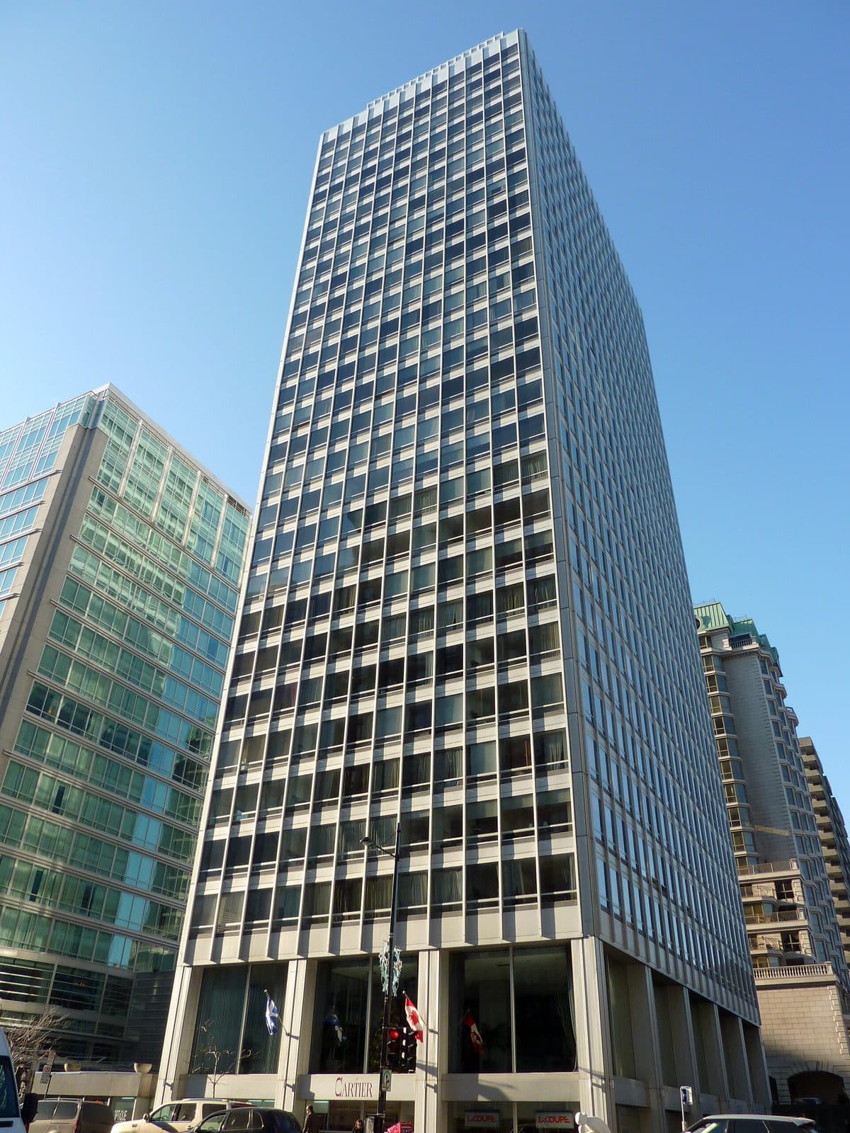 Le Cartier's grid-windowed tower against a blue sky