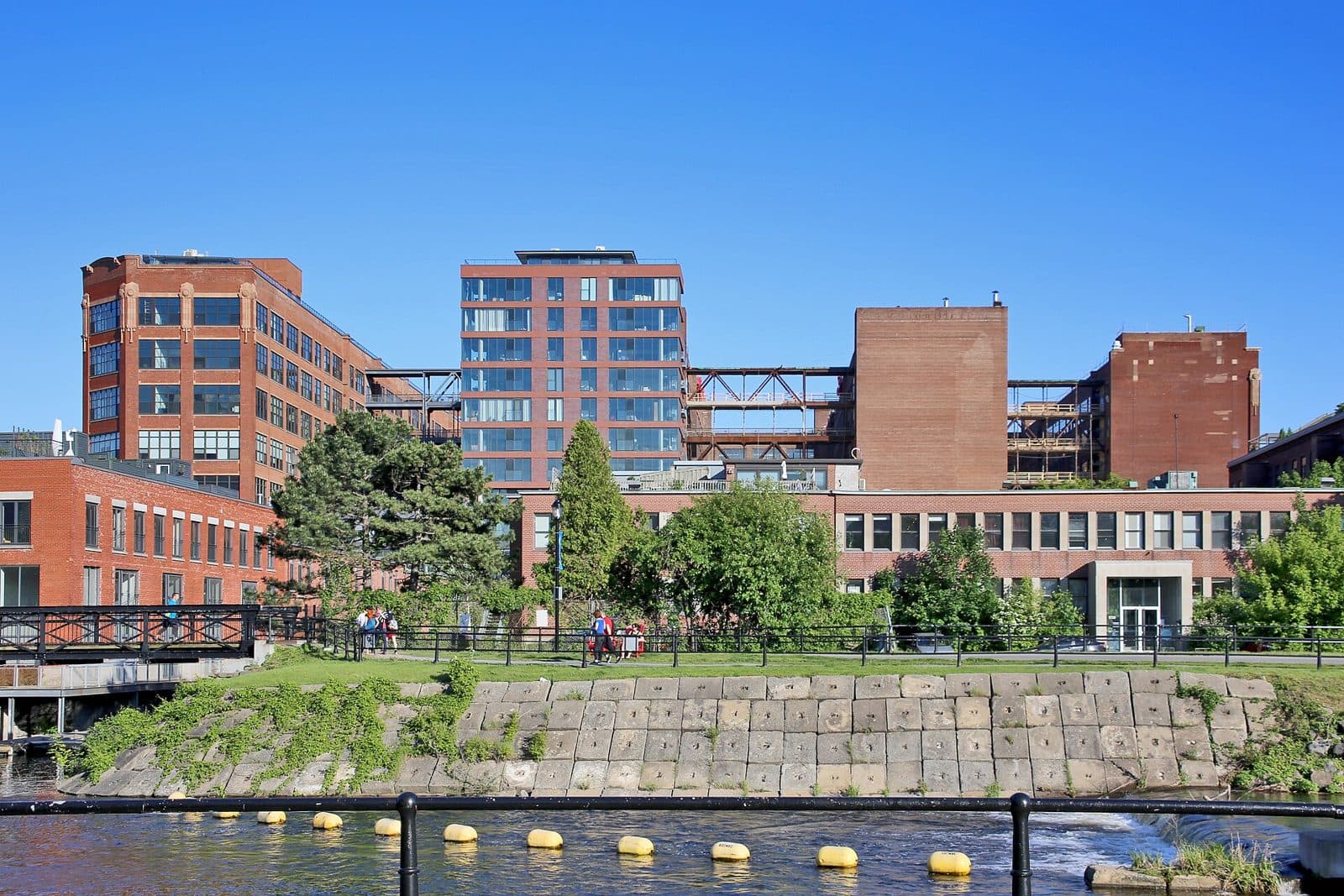 Red brick factory buildings of Le Nordelec seen across the Lachine Canal