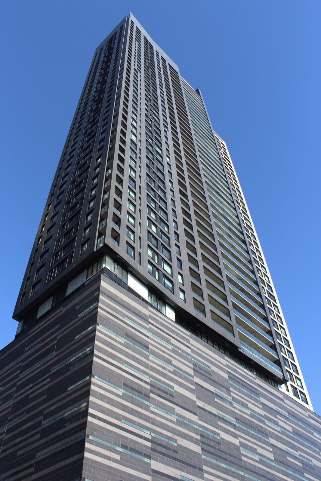 The dark Tour des Canadiens tower with a striped podium, from below