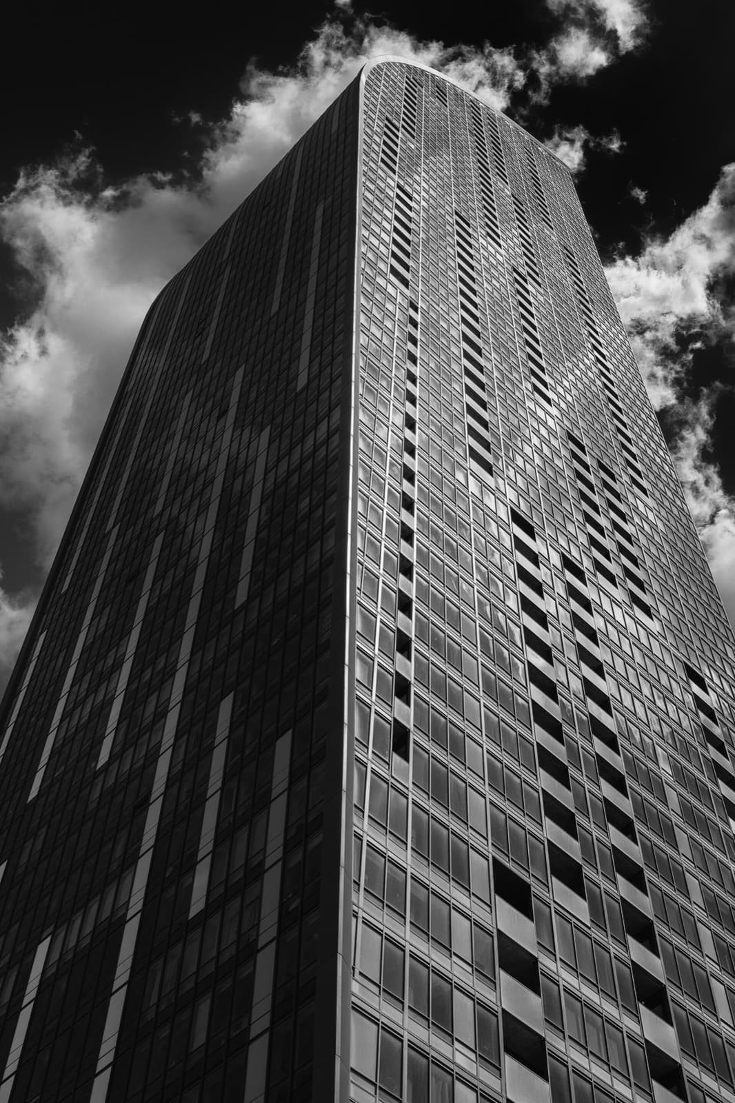 L Tower's curved glass facade rising over The Esplanade in Toronto
