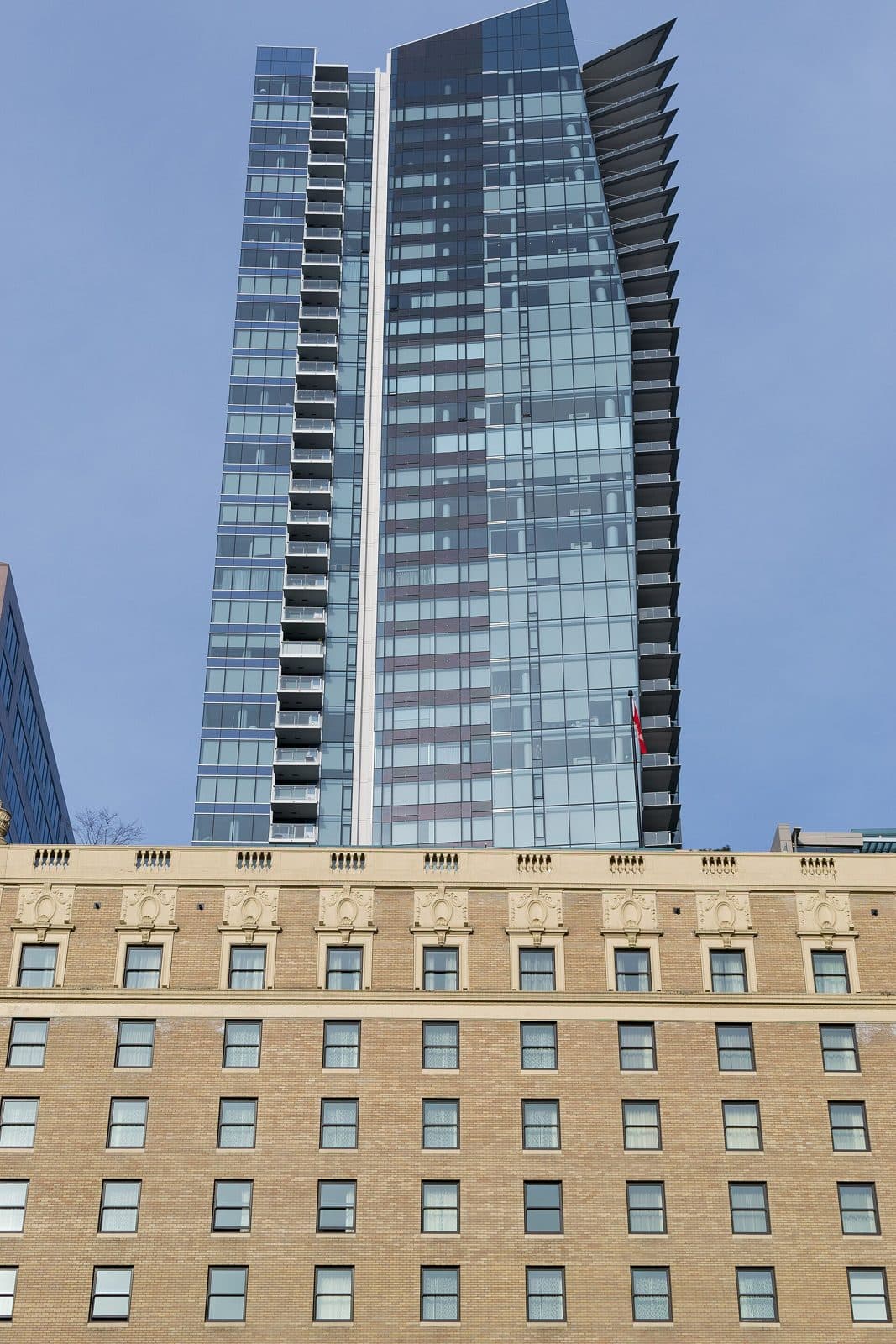 The Private Residences at Hotel Georgia tower rising behind the brick Hotel Georgia