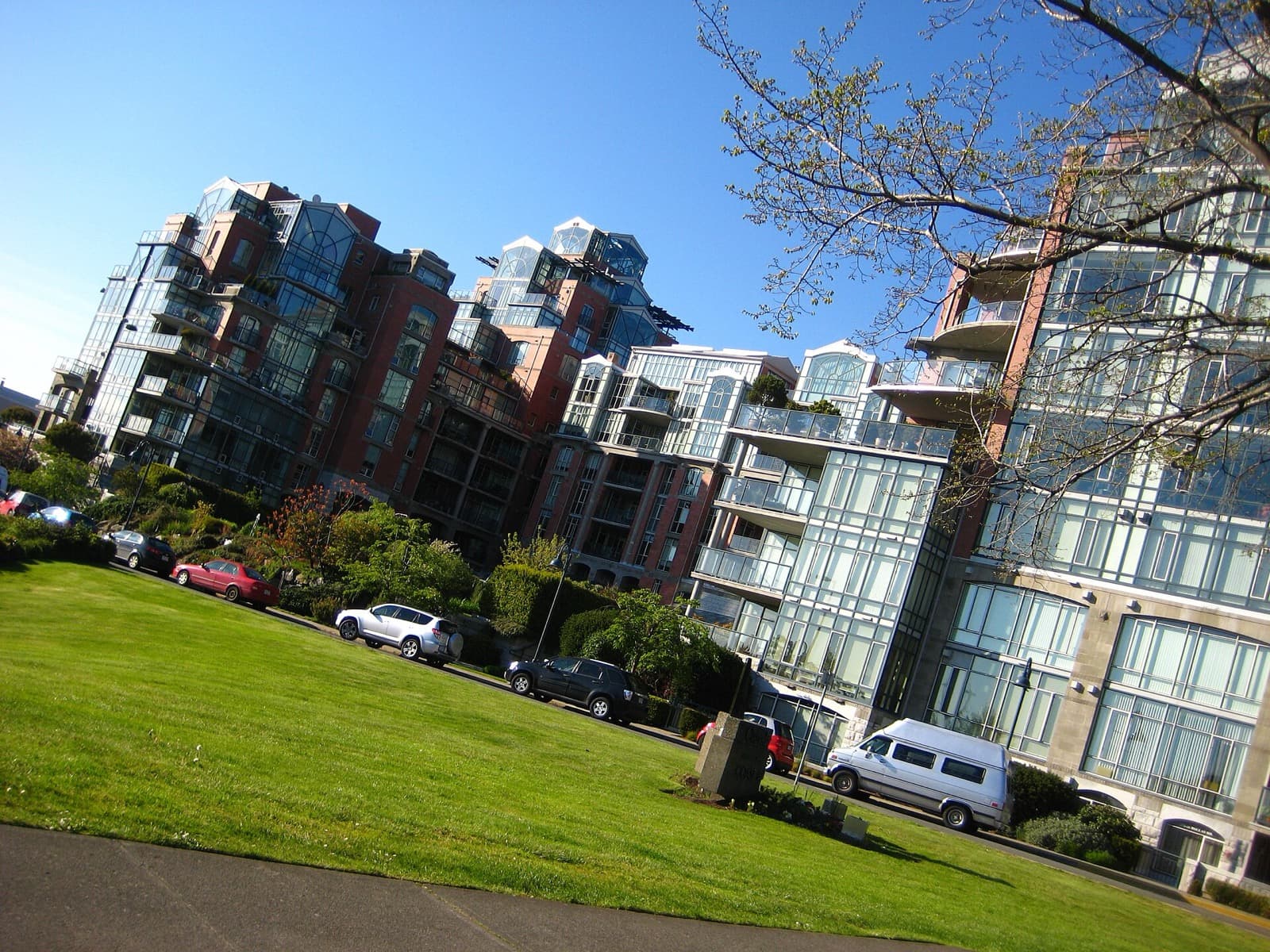 Stepped brick and glass condo wings of Shoal Point seen across a lawn in James Bay