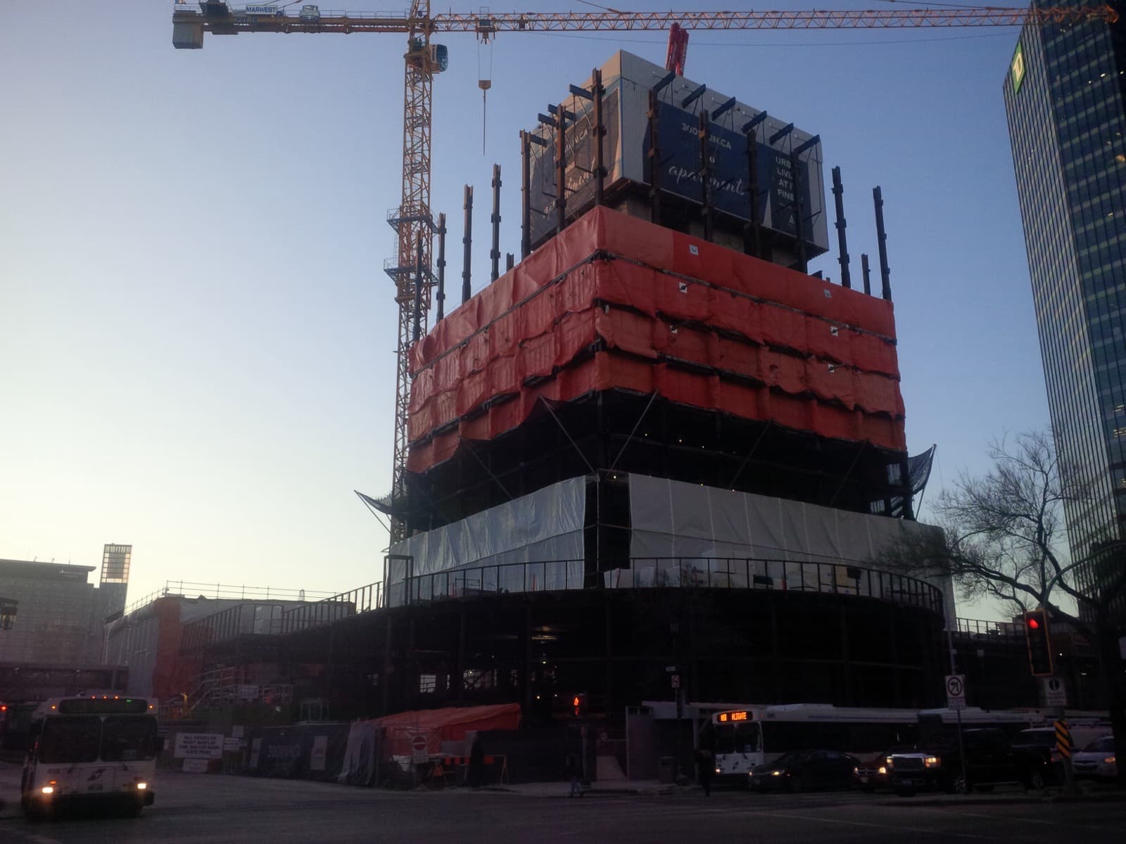 The lower floors of 300 Main under construction behind hoarding and a tower crane